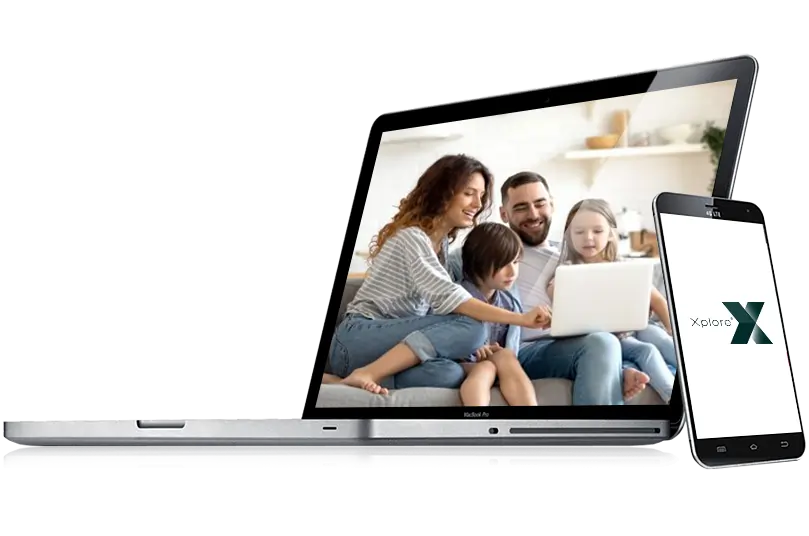 Laptop with image of family on a couch on the screen with mobile phone leaning against laptop.