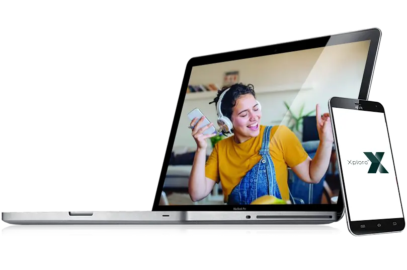 Laptop with image of girl listening to music on the screen with mobile phone leaning against laptop.