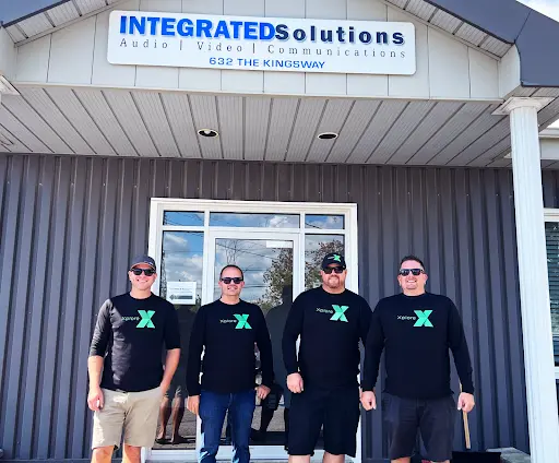 Four Integrated-Solutions workers standing outside an establishment