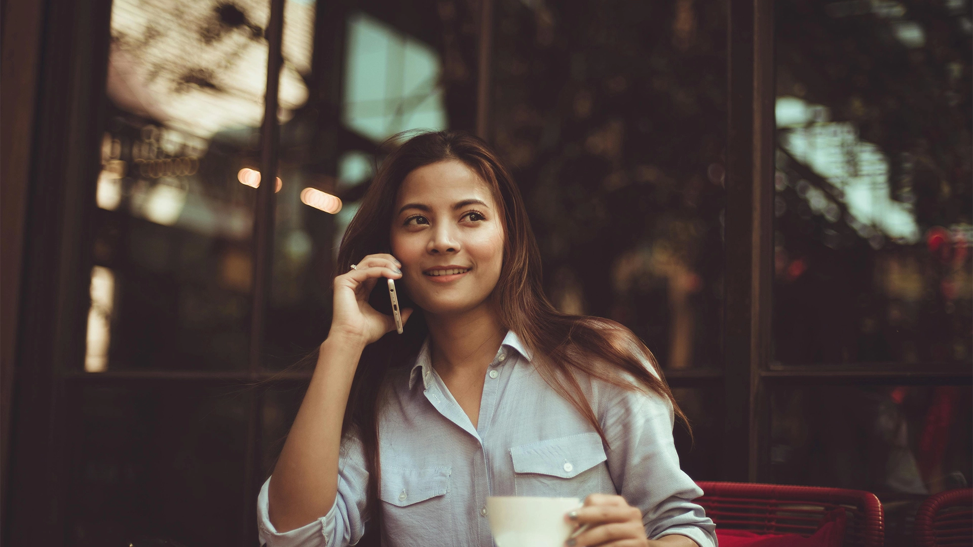 Woman sitting on a phone call holding a mug