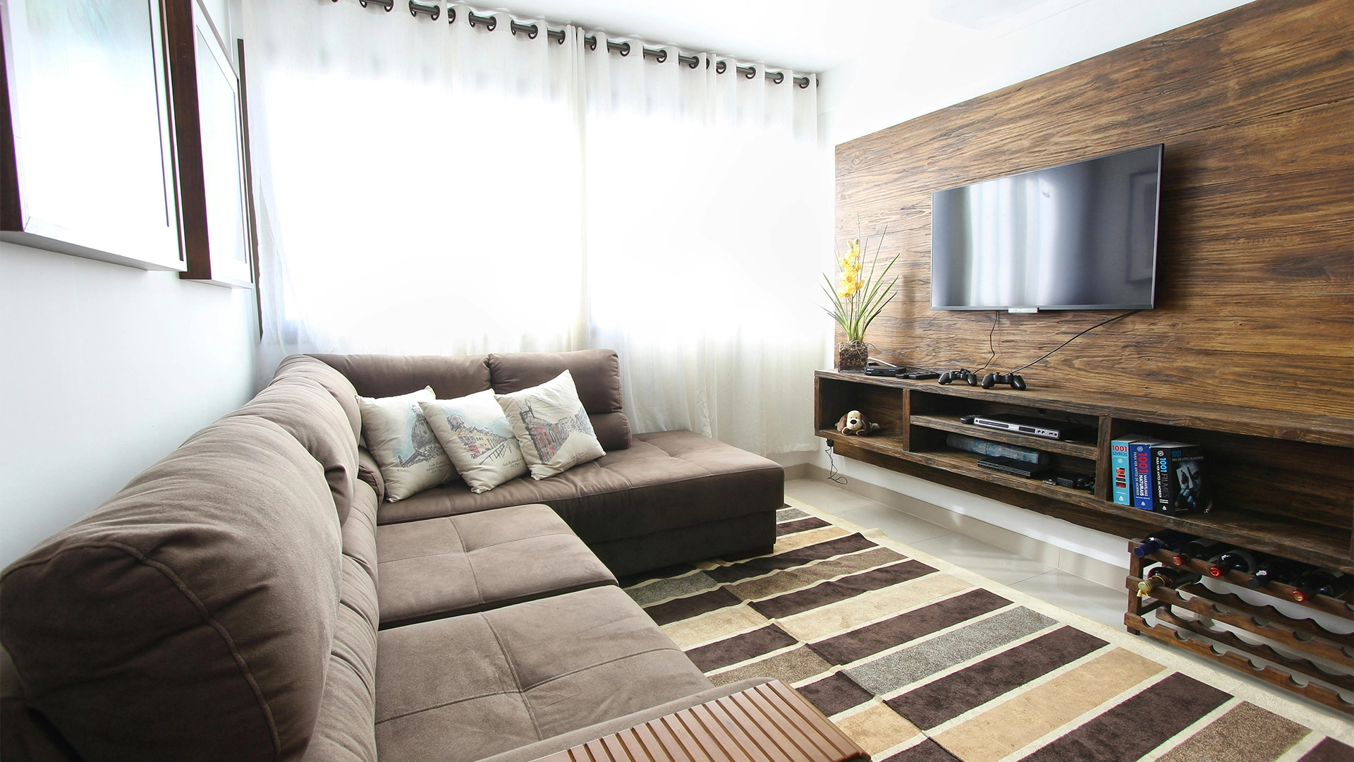 Home Living Room with a Grey Sofa and a TV mounted on the Wall