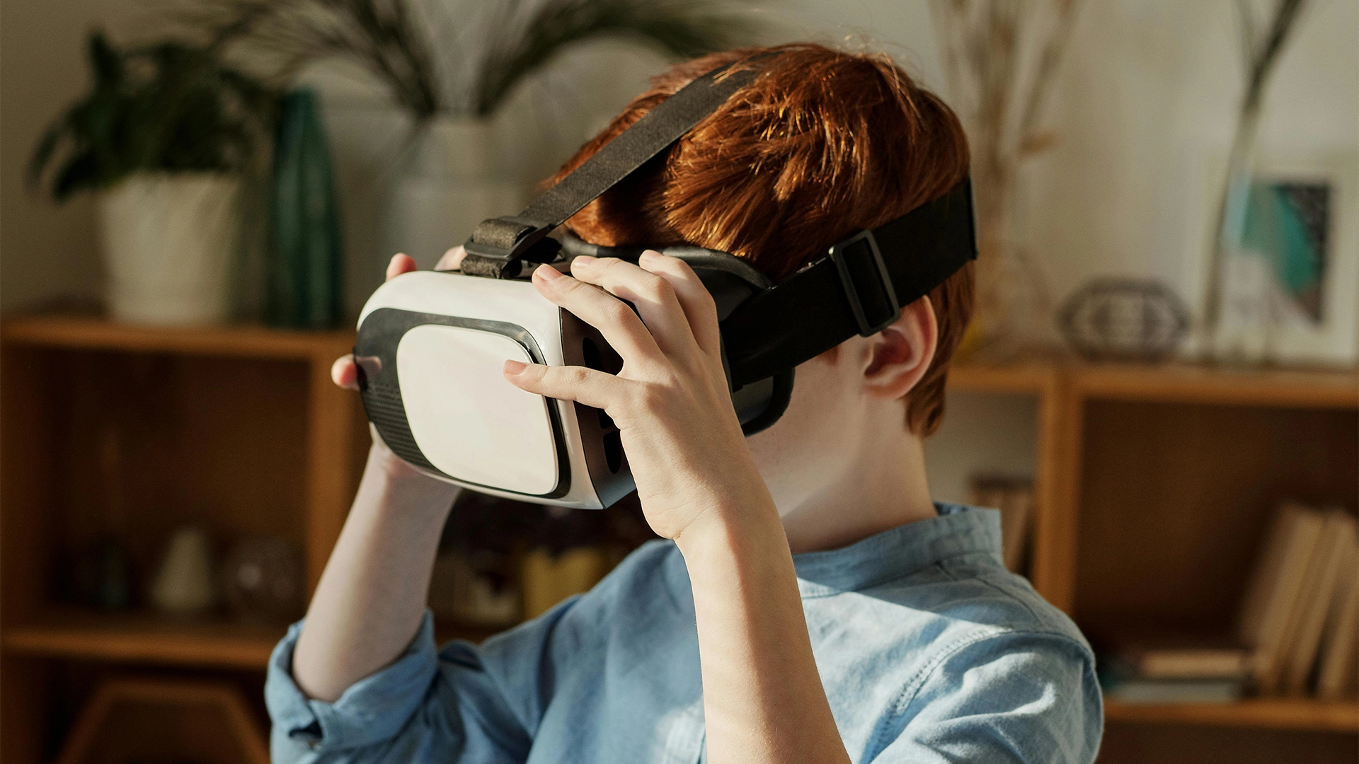 Kid playing/using a VR (Virtual Reality) headset.